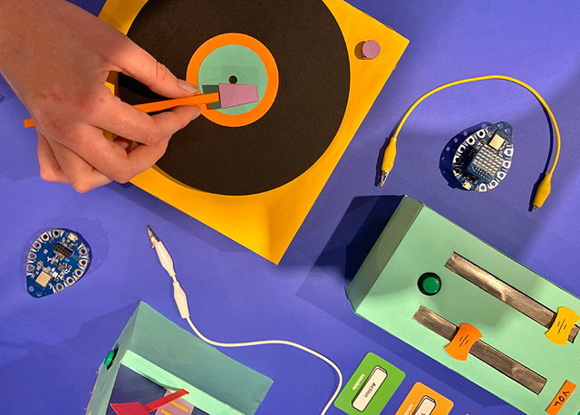 Teknikio Bluebird next to a record player on a blue background