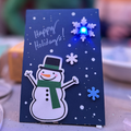 Teknikio blue LED light holiday card featuring a snowman and foam snowflakes